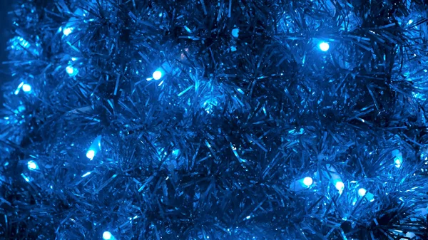 Decoración de Navidad brillante, luces de colores de bombillas, guirnaldas y oropel brillante de color azul. Concepto. Primer plano del oropel de Año Nuevo y luces parpadeantes . —  Fotos de Stock