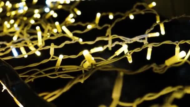 Close-up lights garlands shine on street at night. Concept. Beautiful shining and twinkling lights garlands on background of city night — Stock Video