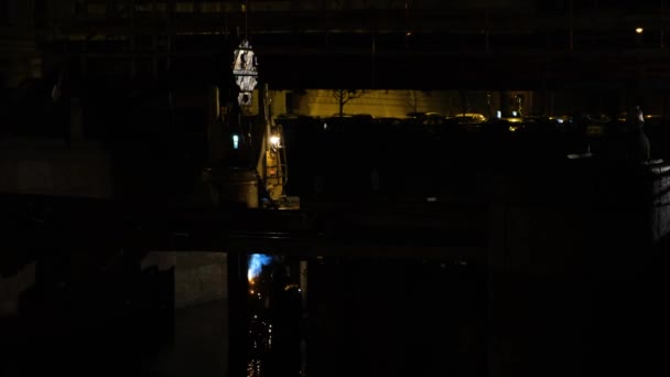 Zamaskowany spawacz pracuje w nocy w mieście. Koncepcja. Widok ciemnej opuszczonej części miasta z działającym spawaczem w nocy. Zamaskowany spawacz wykonuje prace spawalnicze nad wodą w nocy — Wideo stockowe