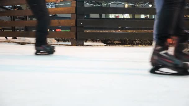 Des gens qui passent des patins sur la glace. Concept. Gros plan des gens qui patinent sur la glace en hiver. Les gens se détendent activement en patinant sur la patinoire — Video