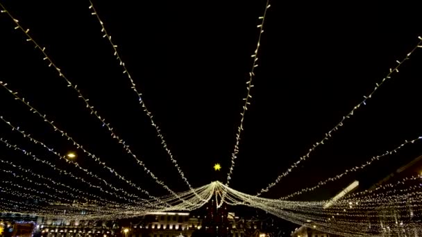 Яркие сверкающие украшения праздничного Нового Года ночью. Концепция. Светящиеся украшения с гирляндами освещают ночной город и создают праздничное новогоднее настроение — стоковое видео