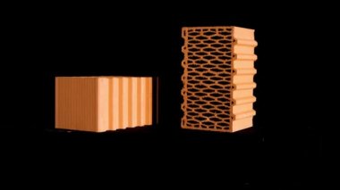 Siyah standın üzerine iki yeni delinmiş kırmızı tuğla, inşaat ve inşaat malzemeleri konsepti. Stok görüntüleri. Siyah arkaplanda hareket eden tuğlalar.