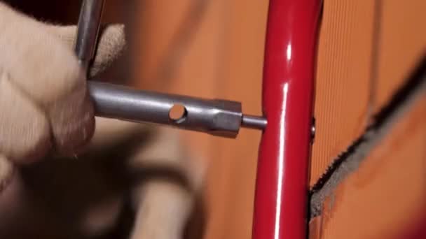 Close up de um trabalhador do sexo masculino mãos usando chave de encaixe para anexar tubo de metal para a parede de tijolo vermelho. Imagens de stock. O processo de construção de casas . — Vídeo de Stock