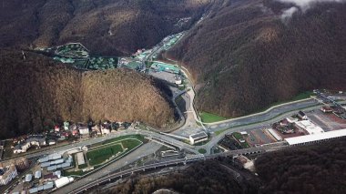 Sonbaharın sonlarında büyük bir otel kompleksi ve dağ kenti. Stok görüntüleri. Ağır bulutların altında ağaçlarla kaplı nefes kesici yamaçlar..