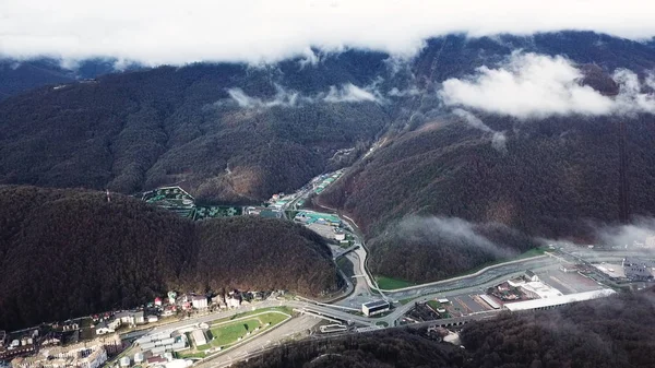Large hotel complex and mountain resort in late autumn. Stock footage. Breathtaking hill slopes covered by trees under the heavy clouds.