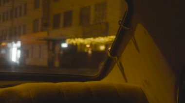 Şehir ışıkları altında arabanın içi aydınlık. Stok görüntüleri. Retro arabanın arka tarafındaki yakın çekim geceleri yol ışıklarıyla aydınlatılır.