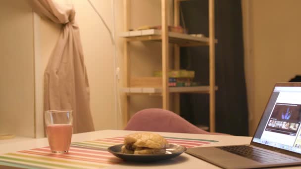 İçinde sandviç ve dizüstü bilgisayarı olan bir masa. Stok görüntüleri. Mutfak masası ve akşam laptopuyla basit bir ev içi. — Stok video