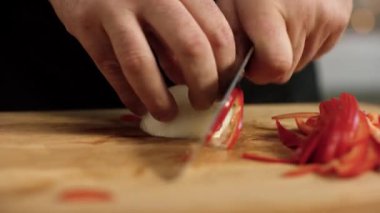 Soğan doğrayan profesyonel aşçıya yakın çekim. Stok görüntüleri. Profesyonel restoran şefinin ellerinde keskin bıçakla soğan dilimlemek.