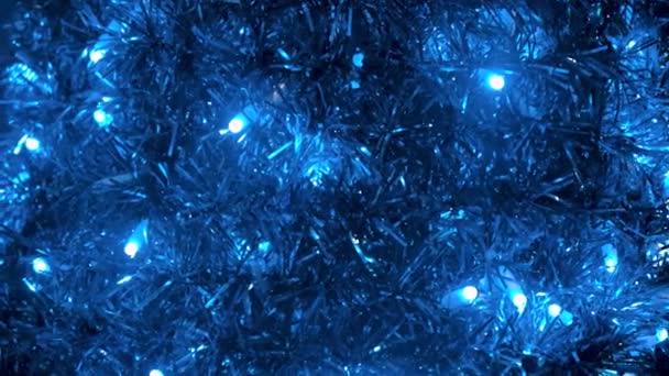 Bright Christmas decoration, colorful lights of bulbs, garlands and shiny tinsel of blue color. Concept. Close up of New Year tinsel and blinking lights. — 비디오