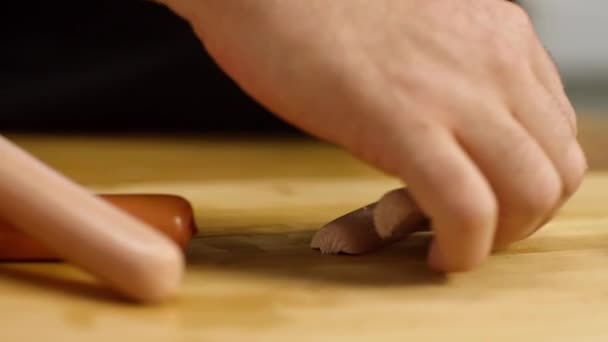 厨师切碎香肠的特写。库存录像。厨师在木板上切薄片多汁的粉红色香肠披萨.在厨房里有专业的烹调工艺 — 图库视频影像