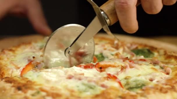 Nahaufnahme der Pizza wird mit rundem Messer geschnitten. Archivmaterial. leckere heiße Pizza wird mit professionellem Rundmesser für glatte Scheiben geschnitten — Stockvideo