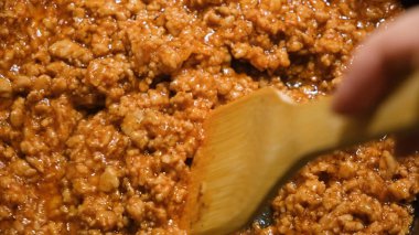 Sosla pişirilmiş et yakın plan. Kavram. Kıyma büyük miktarda tavada sosta kızartılır. Soslu kıyma sosunun profesyonel pişirilmesi.