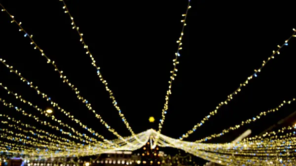 Jasné třpytivé dekorace slavnostního Nového roku města v noci. Koncept. Zářící dekorace s girlandami osvětlují noční město a vytvářejí slavnostní novoroční náladu — Stock fotografie