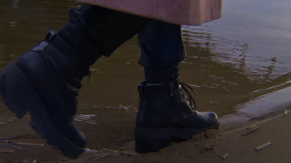 Close-up of woman walking on water in shoes. Stock footage. Woman in black stylish leather shoes walks on water walking on beach in evening — 스톡 사진