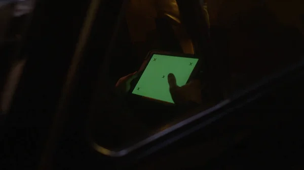 Close-up of man riding in atomobile and sitting in tablet. Stock footage. Man rides through dark tunnel in car and works while driving on tablet with green screen — Stock Photo, Image