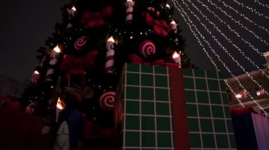 Noel ağacı ışıkları ve gece gökyüzü arka planında süslemeler. Kavram. Mumlar ve kurdelelerle ladin ağacının alt manzarası.