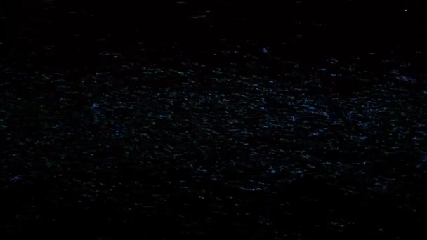 Luci blu sfocate riflesse sulla superficie dell'acqua con increspature nella notte buia. Concetto. Primo piano della superficie colorata del fiume con piccole onde . — Video Stock