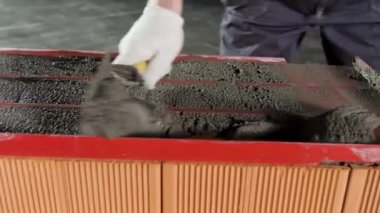 İnşaat alanındaki tuğla ustasını malayla kapatın. Stok görüntüleri. Dış duvarları tuğla ve harçla örmek için mala kullanan sanayi işçisi..