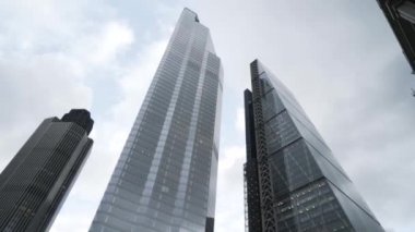 Cama yakın ve berrak su ile mor boya damlaları karıştırılıyor. Kavram. Leylak boya fırçası şeffaf suya dökülüyor. Güzel boya bulutlarıyla..