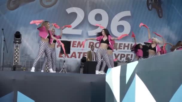 Jekatěrinburg, Rusko-srpen, 2019: Profesionální tanečnice na jevišti v pozadí davu. Akce. Tanečníci vystupují na pódiu v pozadí davu lidí na letním koncertě — Stock video