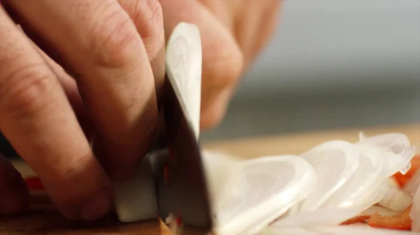 Primo piano dello chef professionista che affetta cipolle. Filmati delle scorte. Affettare cipolle per piatto con coltello affilato in mani di chef di ristorante professionale — Foto Stock