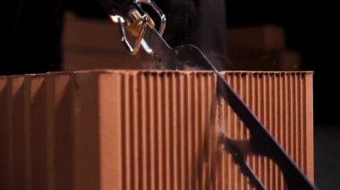 İnşaat işlemine seramik bloklar hazırlamak için otomatik testere kullanan bir işçiyi kapatın. Stok görüntüleri. Küçük elektrikli testereyi çalıştırdı..