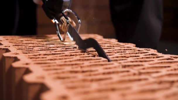 Close-up van een man die elektrische zaag gebruikt om door een blok in een stofwolk te snijden. Voorraadbeelden. Details van nieuwe bakstenen huis gebouw. — Stockvideo
