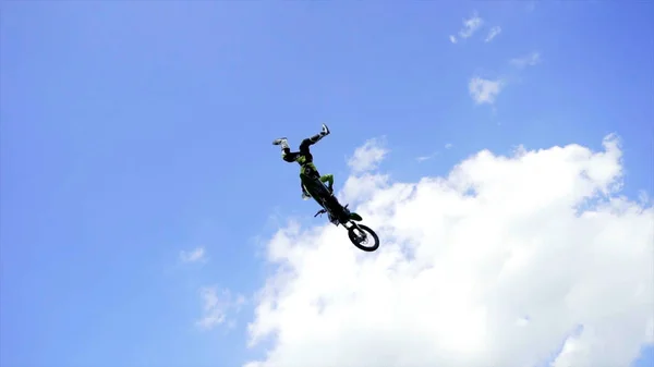 Ekaterimburgo, Rusia-agosto de 2019: Los motociclistas realizan acrobacias. Acción. Motociclistas profesionales realizan trucos desde trampolines sobre fondo de stands con gente y cielo azul — Foto de Stock