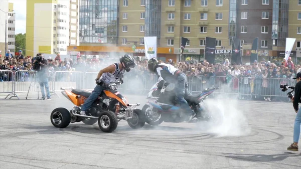 Jekatěrinburg, Rusko-srpen, 2019: Čtyřkolka a motocyklista předvádějí kaskadérské kousky. Akce. Profesionální jezdci na motocyklové dopravě provádět triky na místě se nachází ve městě pro festival Moto — Stock fotografie