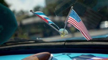 Arabayla Amerika ve Küba 'nın bayraklarını yakın plan çek. Başla. Güzel bayraklar, Hot Country 'de arka plandaki eski araba panelini süslüyor. Araba için dekorasyon