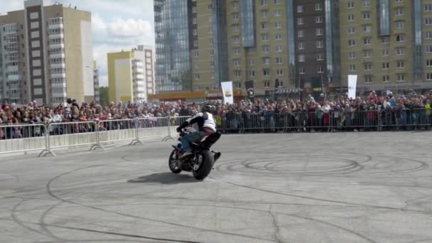 Yekaterinburg, Rússia-agosto de 2019: Passeios de motociclista na frente da multidão no show de motocicletas. Acion. O motociclista profissional vira agudamente na multidão de pessoas que estão atrás da cerca em — Vídeo de Stock