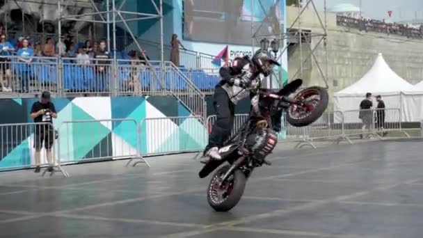 Yekaterinburg, Russia-August, 2019: Motorcyclist performs stunts on background of people. Action. Professional motorcyclist performs beautiful stunts on background of stands with people at freestyle — Stock Video