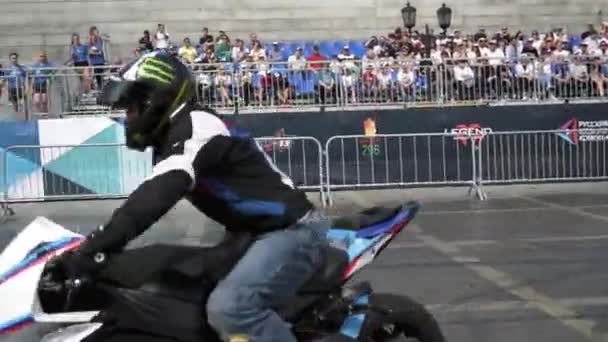 Jekatěrinburg, Rusko-srpen, 2019: Motorkář provádí kaskadérské výkony na pozadí lidí. Akce. Profesionální motocyklista provádí krásné kousky na pozadí stánků s lidmi na freestyle — Stock video