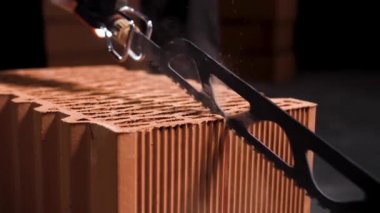 Siyah arkaplanı kesen tuğlalar için elektrikli testereyi kapatın. Stok görüntüleri. Yeni tuğla evler inşa etmek ve inşa etmek.