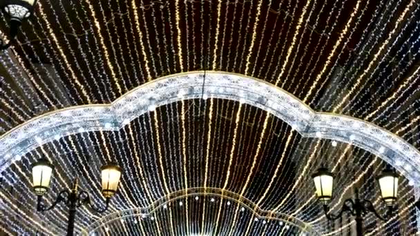 Decoración de luz navideña en la calle de la ciudad por la noche. Concepto. Guirnaldas de Año Nuevo y linternas viejas sobre fondo de cielo negro . — Vídeo de stock