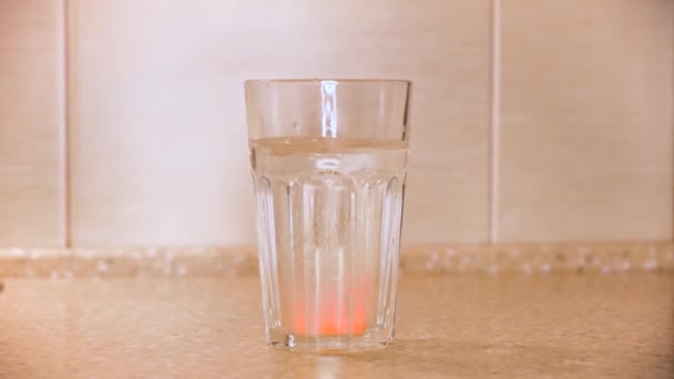 Αναβράζον δισκίο παυσίπονου τοποθετείται σε ένα ποτήρι νερό, ασθένεια και φάρμακο. Έννοια. Κοντινό πλάνο του χεριού ρίχνουν φάρμακα στο νερό. — Αρχείο Βίντεο
