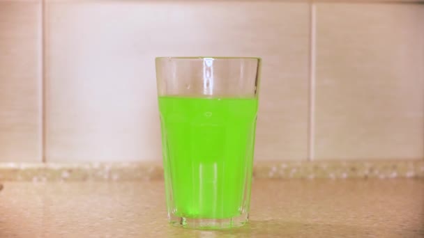 Κοντινό πλάνο αφρώδεις φυσαλίδες σε ένα ποτήρι κρύο νερό πολυβιταμίνης διαλυμένο από αναβράζοντα χάπια δισκίων. Έννοια. Σπιτικό ανθρακούχο ποτό με γεύση φρούτων — Αρχείο Βίντεο