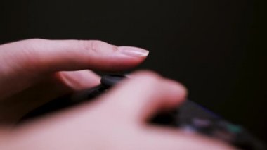 Kız oyuncu, siyah arka planda kablosuz joystick ile video oyunu oynuyor. Kavram. Oyun alanının kapatılması kadın ellerinde, kumar bağımlılığı.