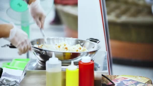 Cocinar verduras con arroz en un café callejero en un mercado local en Tailandia. Art. Primer plano de un hombre preparando un delicioso plato de cocina tailandesa en una sartén . — Vídeos de Stock