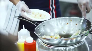 Tayland 'da yerel bir markette pirinç ile sebze pişirmek. - Sanat. Kızartma tavasında Tayland mutfağı hazırlayan bir adama yaklaş..