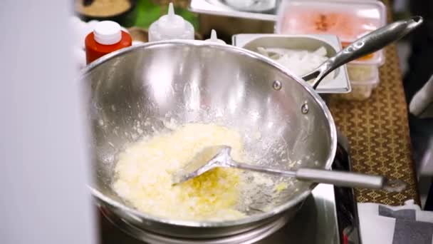 Primo piano di mani di cuoco preparare delizioso piatto fresco con riso in padella. Art. Vista laterale di un uomo che mescola accuratamente ingredienti con un sacco di olio . — Video Stock