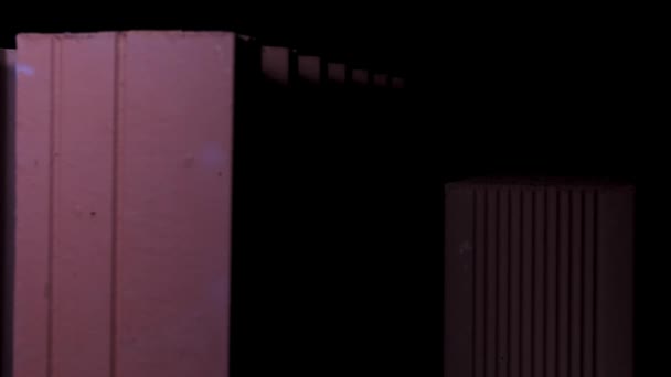 Närbild av nya tegelstenar på byggarbetsplatsen under facklans rörliga ljus. Lagerbilder. Rektangulära keramiska block på svart bakgrund. — Stockvideo