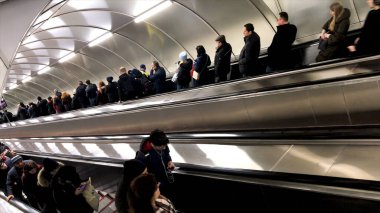 Metro istasyonuna girmek ya da çıkmak için yürüyen merdiveni kullanan insanların en üst görüntüsü. Stok görüntüleri. Yeraltı toplu taşıma konsepti, yoğun insanlar yoğun saatlerde.