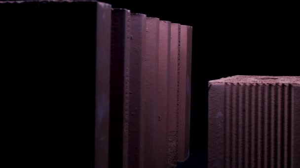 Gros plan de briques isolées sur fond noir. Images d'archives. Deux grands blocs de céramique sous la lumière mobile de la lampe de poche .