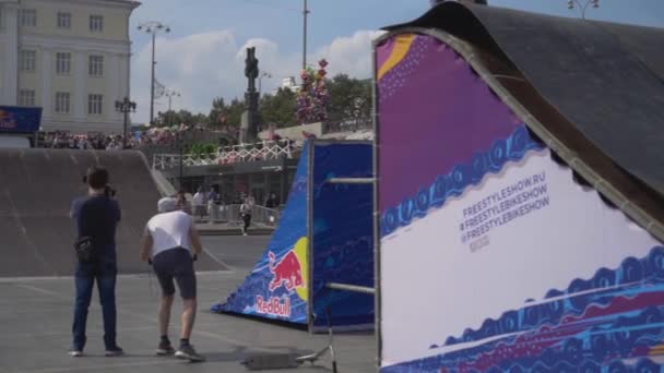 Yekaterinburg,ロシア- 8月, 2019:スクーターの十代はトリックを実行します.行動だ。スクーターの専門家は、ランプからトリックを実行し、フリースタイルショーに落ちる — ストック動画