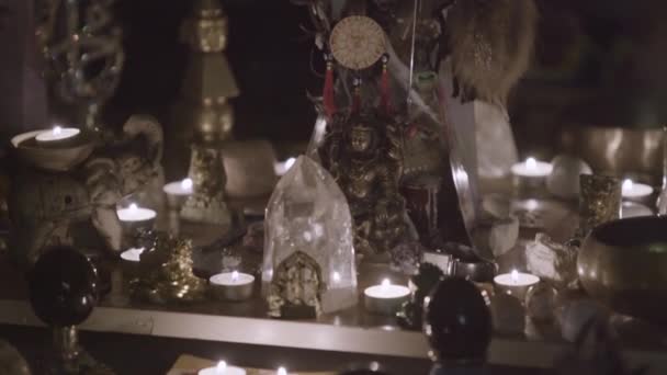 Zblízka Feng Shui oltář doma v obývacím pokoji na stole. Umění. Atraktivní koncept bohatství a prosperity, rystalové shluky, zlatá Buddhova postava a svíčky.