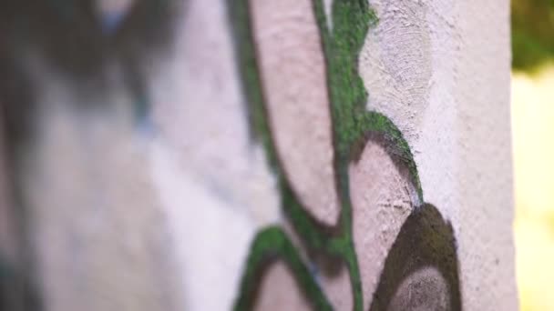 Una mano con uno spray che disegna un nuovo graffito sul muro con uno spray di vernice. Art. Primo piano del processo di disegno di un graffito su un muro di cemento, il concetto di street art e vandalismo illegale . — Video Stock