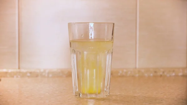 Effervescent painkiller tablet being put in a glass of water, disease and medicine. Concept. Close up of the hand throwing medicament into water. — Stock Photo, Image