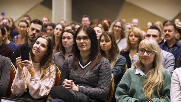 London - England, 02.08.2020: Feminist women attend seminar sitting in a conference room. Art. Women listen to the speaker and clapping hands, equal rights concept.
