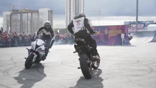 Yekaterinburg, Rusland-augustus 2019: Motorrijders doen trucs op freestyle show. Actie. Professionele motorrijders voeren stunts op de achtergrond van de menigte van mensen achter het hek — Stockvideo